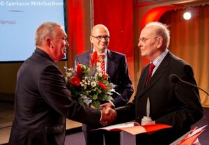 Volker Haupt vom Hilliger e. V. (li.) und Prof. Hans-Ferdinand Schramm, Vorstandsvorsitzender der Sparkasse Mittelsachsen (Bildmitte), gratulieren Herrn Dr. Rainer Thümmel zur Ehrung.